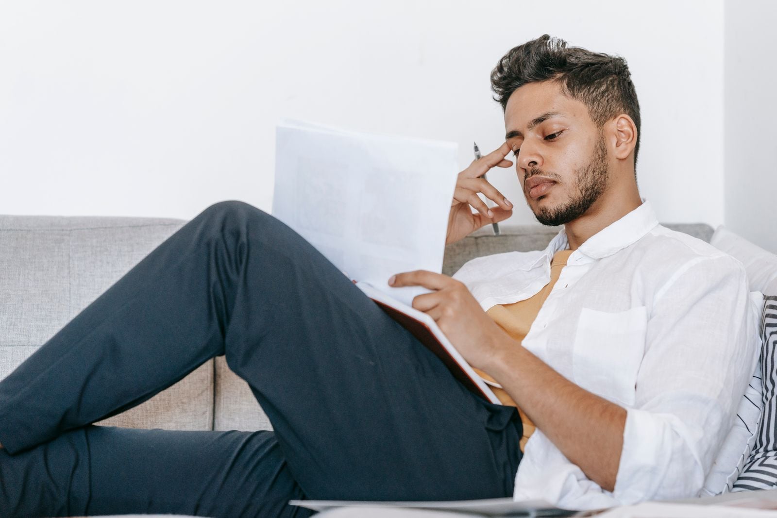 Hombre latino revisa una carta y documentos del IRS con preocupación y busca un siguiente paso